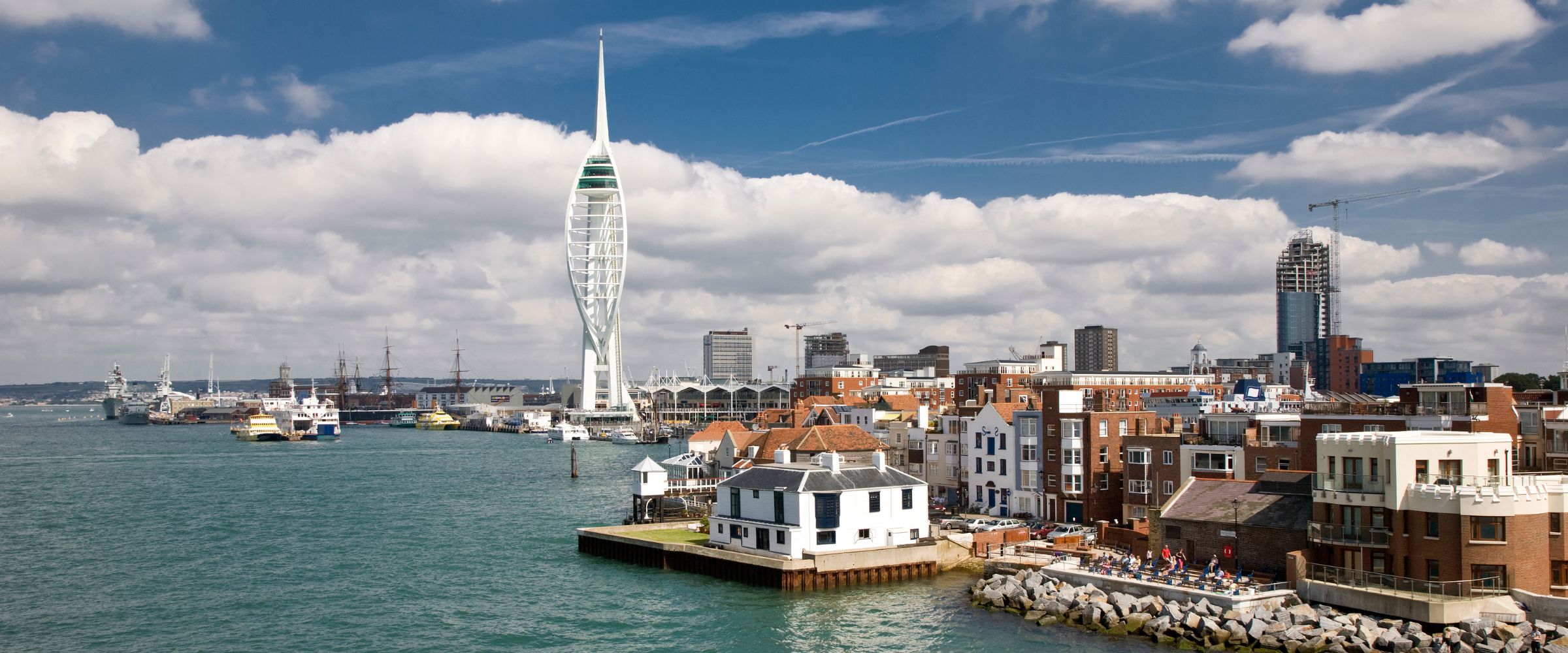 Portsmouth harbour waterfront, with the Spinnaker Tower and moored ships.